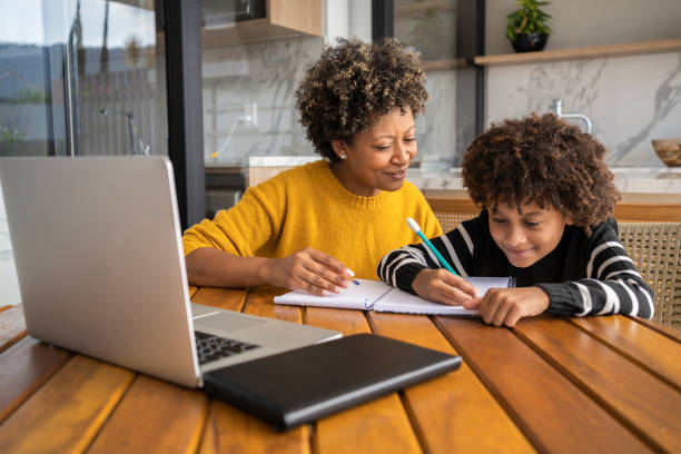 istock African american mom helping son to study online. Homeschooling education during quarantine. 1320362508