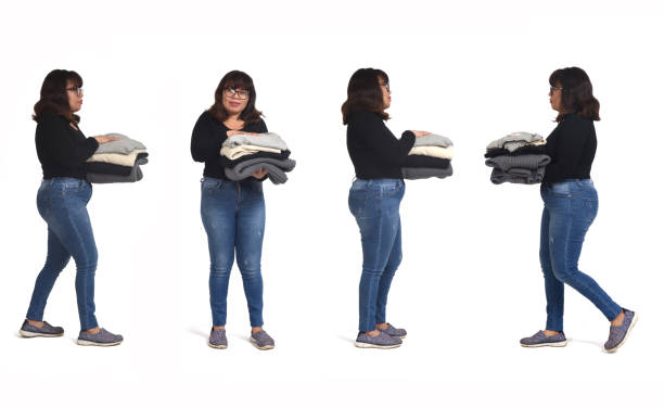 group of a same latin woman holding a pile of clean clothes on white background