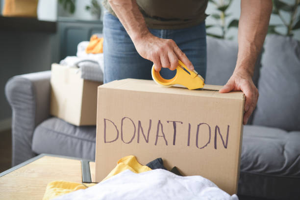 istock mature adult man puts donations in a box 1320366457
