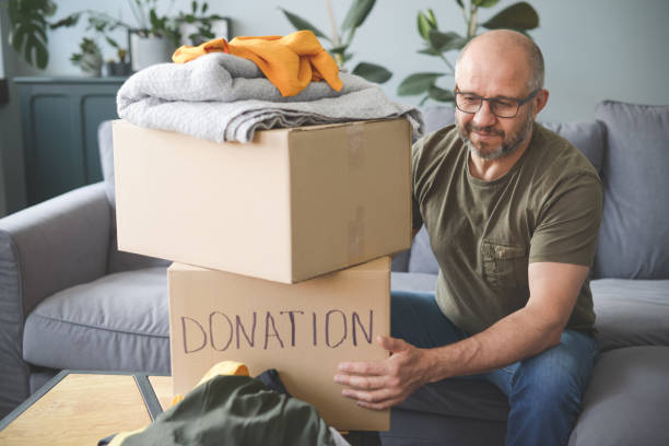 istock mature adult man puts donations in a box 1320366823