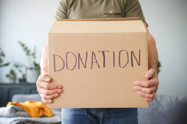 mature adult man puts donations in a box
