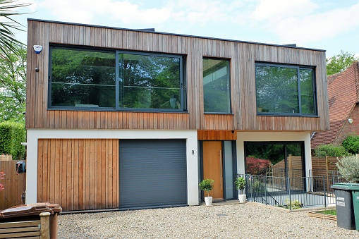 Chorleywood, Hertfordshire, England, UK - May 27th 2021: Modern two storey flat roofed house, clad with external cedar wood