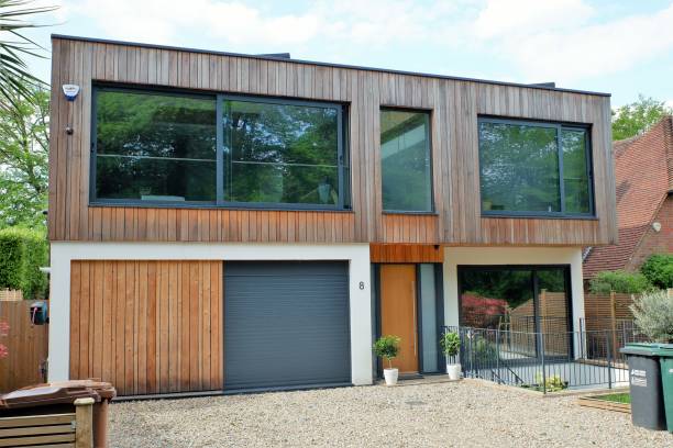 Modern two storey flat roofed house, clad with external cedar wood Chorleywood, Hertfordshire, England, UK - May 27th 2021: Modern two storey flat roofed house, clad with external cedar wood clad stock pictures, royalty-free photos & images