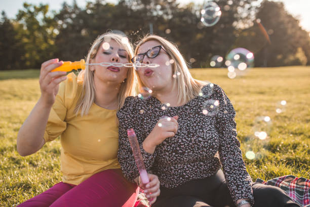 istock Sisters having fun making soap balloons in the park 1320369278