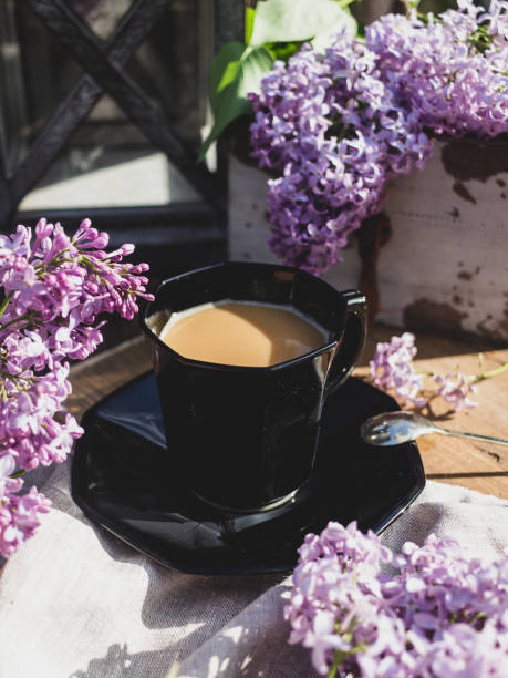 istock Coffee cup with lilac branches on wooden background 1320370169