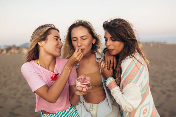 istock Girls eating ice cream on the beach, selective focus 1320372926