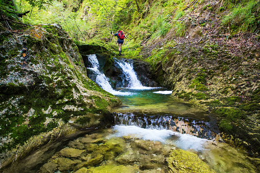 Adult hiker on an adventurous hike through the canyon with fantastic waterfalls ,Gačnik, Soča river, Primorska, Julian Alps. Slovenia, Europe
