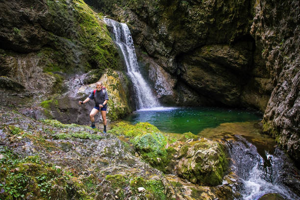 Adult hiker on an adventurous hike through the canyon with fantastic waterfalls ,Gačnik, Soča river, Primorska, Julian Alps. Slovenia, Europe Adult hiker on an adventurous hike through the canyon with fantastic waterfalls ,Gačnik, Soča river, Primorska, Julian Alps. Slovenia, Europe primorska white sport nature stock pictures, royalty-free photos & images