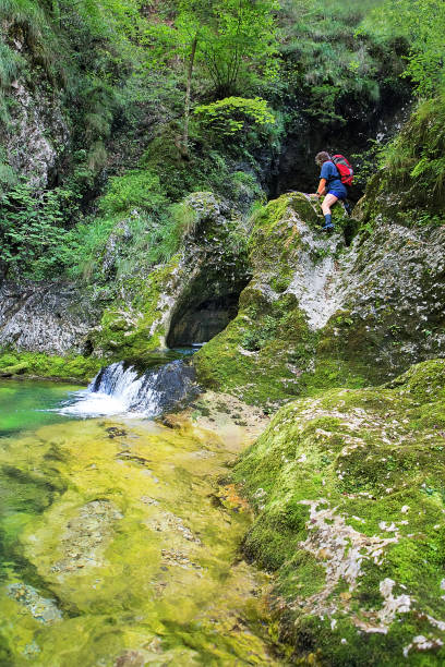 Adult hiker on an adventurous hike through the canyon with fantastic waterfalls ,Gačnik, Soča river, Primorska, Julian Alps. Slovenia, Europe Adult hiker on an adventurous hike through the canyon with fantastic waterfalls ,Gačnik, Soča river, Primorska, Julian Alps. Slovenia, Europe primorska white sport nature stock pictures, royalty-free photos & images