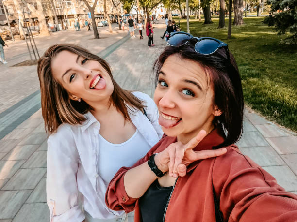 istock Smiling silly women making selfie together 1320377290