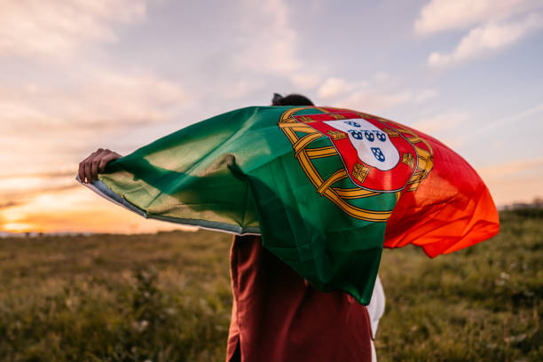 istock Two women holding Portuguese flag on meadow 1320377405