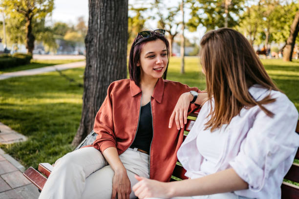 istock Two women chatting on park bench 1320377505