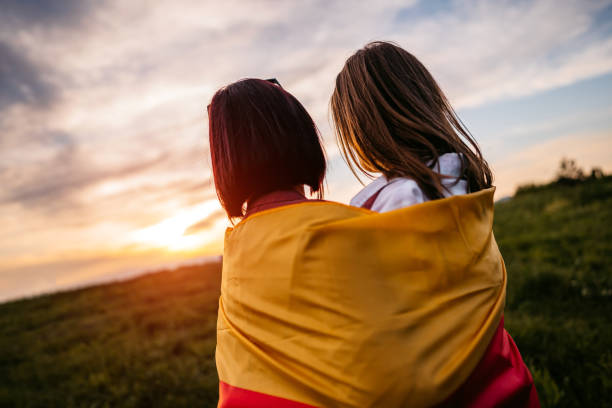 istock Two women  covering themselves with German flag on meadow 1320378410