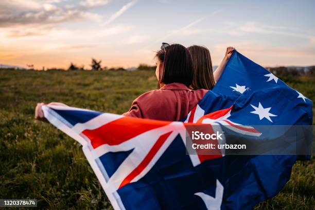 Two Women Covering Themselves With Flag Of New Zealand On Meadow Stock Photo - Download Image Now