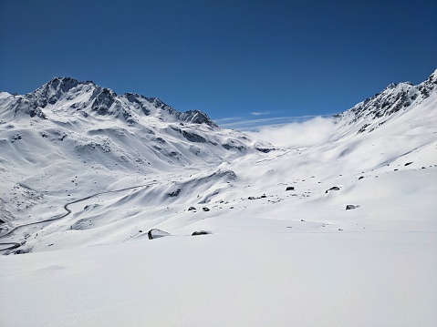 Snow covered mountain landscape in the French Savoie Alps region in the Val Thorens ski area resort during a beautiful clear winter day..