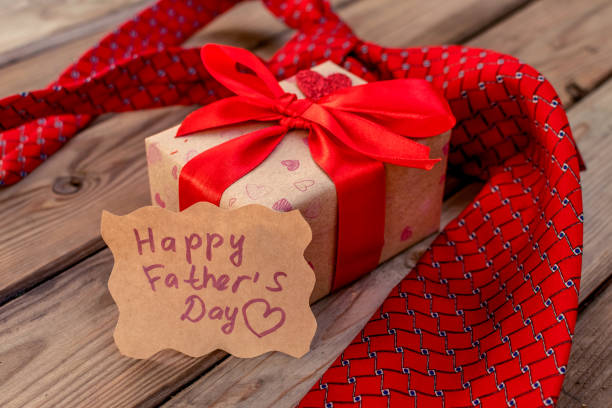 istock Happy Fathers Day gift craft box with red tie on a rustic wood background. 1320381290