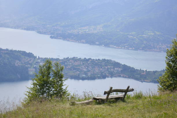 istock Wooden bench standing on hilltop edge with distant lake view 1320382238