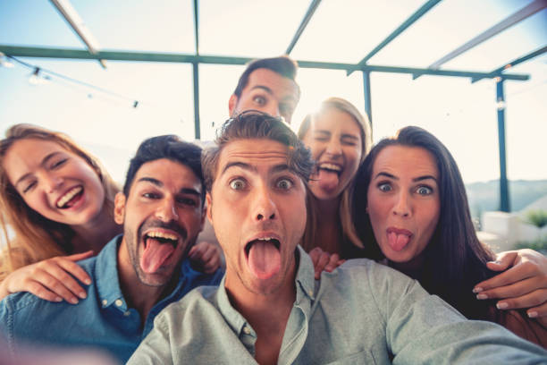 istock Group of friends taking a selfie laughing and smiling and pulling silly faces 1320385211