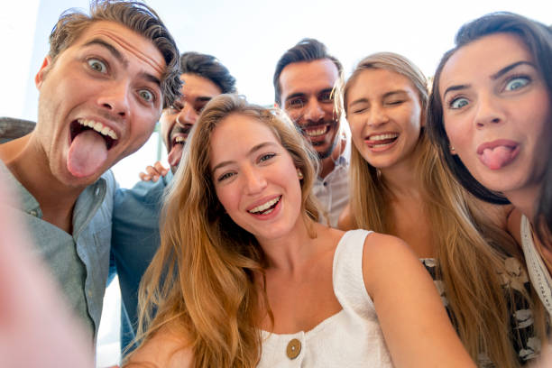 istock Group of friends taking a selfie laughing and smiling and pulling silly faces. 1320385218