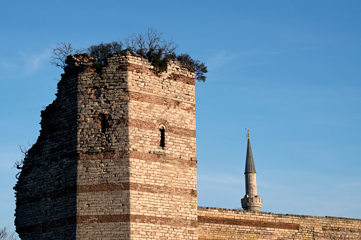 Part of Byzantine Wall with a Minaret in Istanbul. Historical Byzantine wall is towards the blue sky. There is copy space part of that photo.