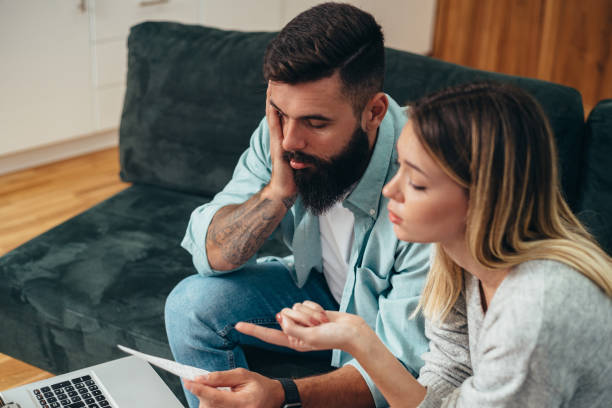 istock Couple using laptop while working on their home finances and bills 1320388575