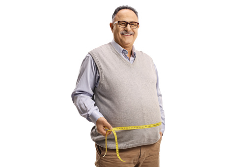 Mature man in casual clothing measuring waist with a tape isolated on white background