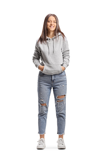 Full length portrait of a female hipster wearing a hoodie and jeans isolated on white background