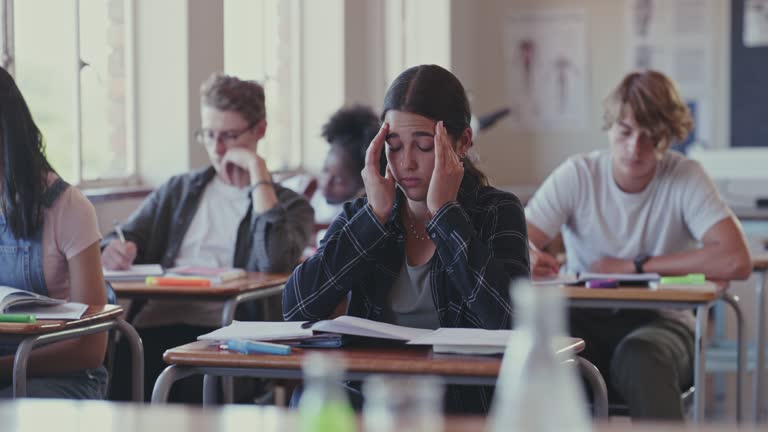 4k video footage of a student struggling with schoolwork in a classroom