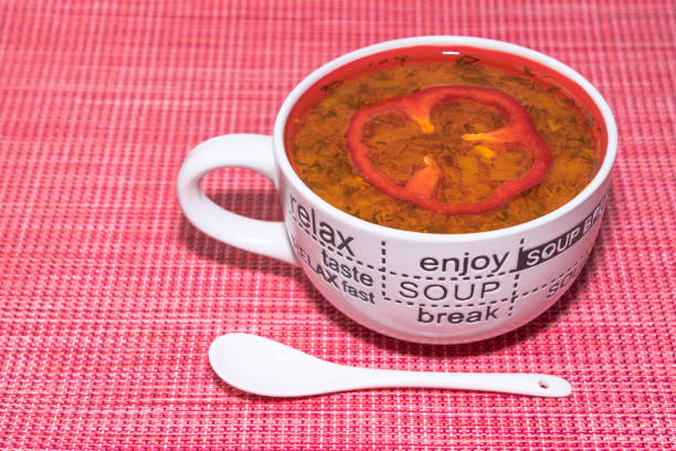 Useful golden coconut milk in a tan cup with turmeric in a wooden spoon on a light blue background.