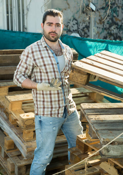istock Man moving wooden pallets 1320389435