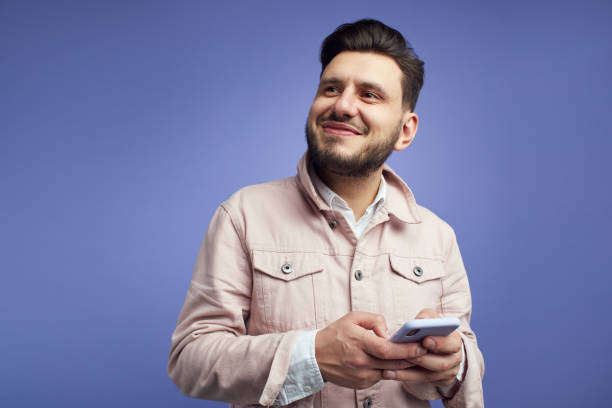 Man holds mobile phone uses app for online communication, concentrated away