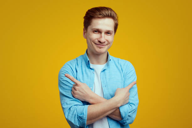istock Smiling man crosses hands over chest, points to both sides, right and left 1320389558