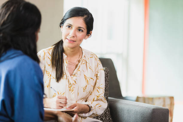 istock Mid adult female counselor takes notes during therapy session 1320392486