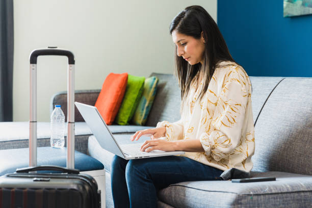 istock Before leaving hotel room, businesswoman does final work on laptop 1320392503
