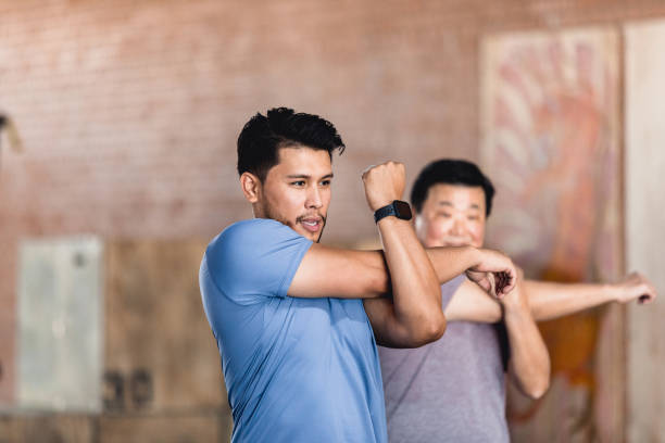 istock Men stretch arms after working out 1320392564
