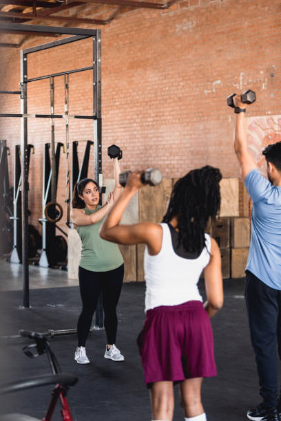 istock People lift weights during fitness class 1320392586