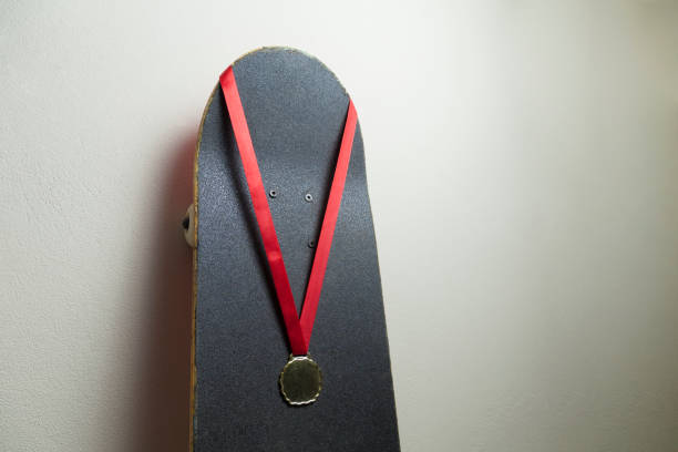 istock Skateboard on the wall with a gold medal. 1320393009