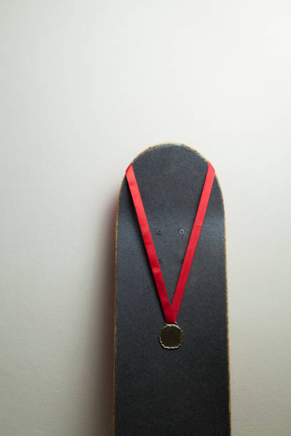 istock Skateboard on the wall with a gold medal. 1320393033