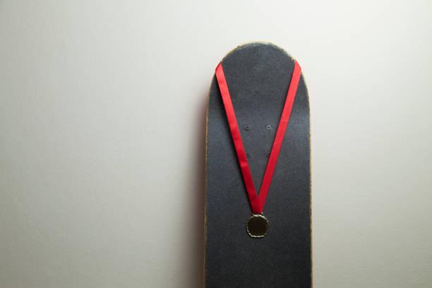istock Skateboard on the wall with a gold medal. 1320393037