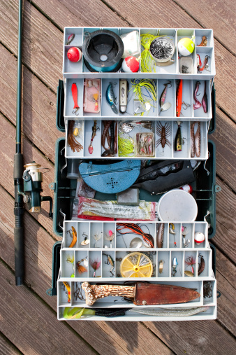 A fully stock fishermans tackle box rod and reel ready for a long day of fishing.