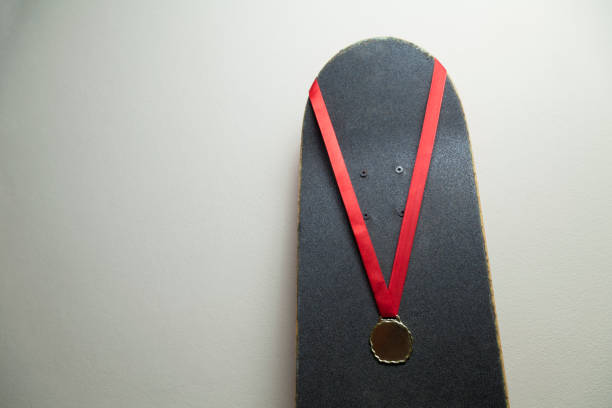 istock Skateboard on the wall with a gold medal. 1320393561
