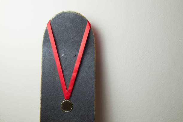 Skateboard on the wall with a gold medal.