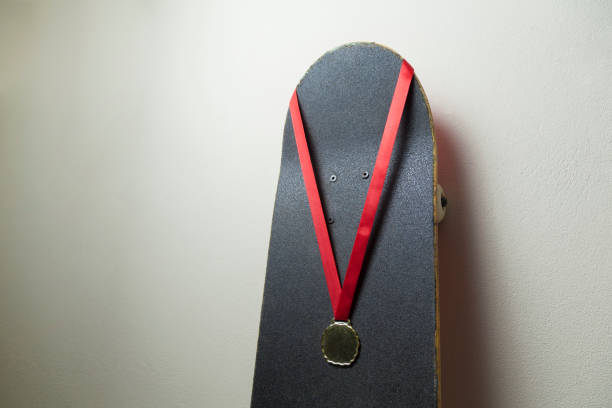 istock Skateboard on the wall with a gold medal. 1320393728
