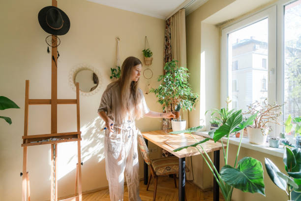 istock Female painter arranging plants at her apartment 1320394642