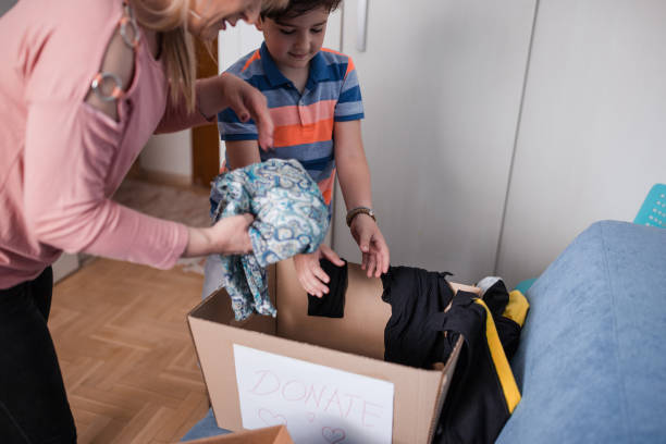 istock Boy and his mother putting clothes at donation box 1320396231