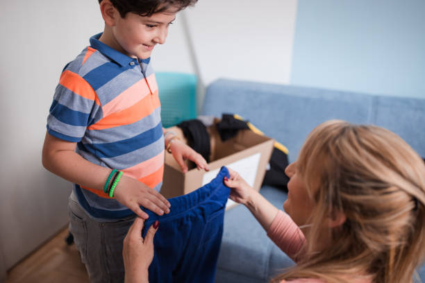 istock Happy boy taking pants his mom is giving him 1320396240