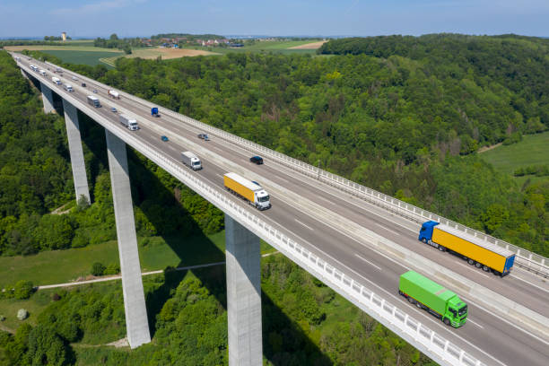istock Trucks on Highway Bridge, Aerial View 1320399353