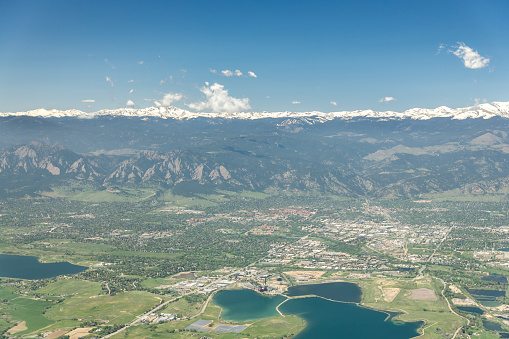 High Altitude aerial view of Boulder, Colorado, USA with snow capped Rocky Mountains in background