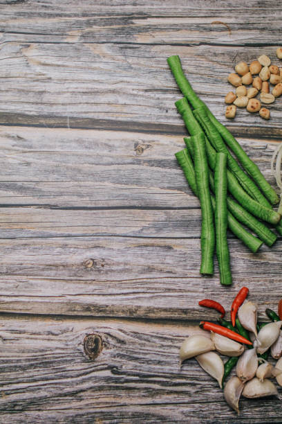 papaya salat (som tam) zutaten auf holztisch hintergrund. das berühmte lokale thailändische streetfood-gericht mit dem geschmack von heiß und würzig. - sour taste green traditional culture lemon stock-fotos und bilder