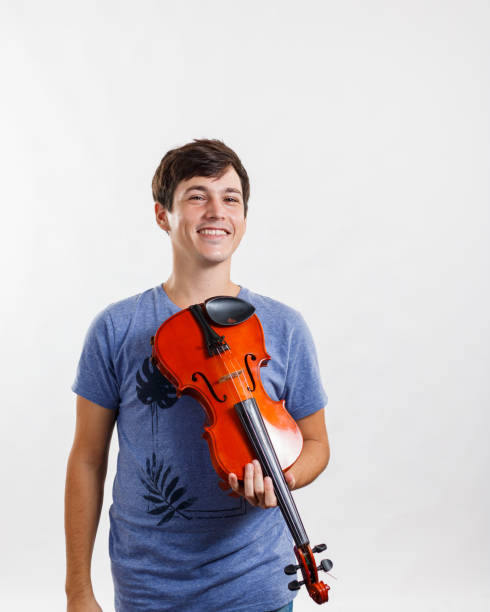 istock Man holding violin in hand and smiling. White background. 1320404911